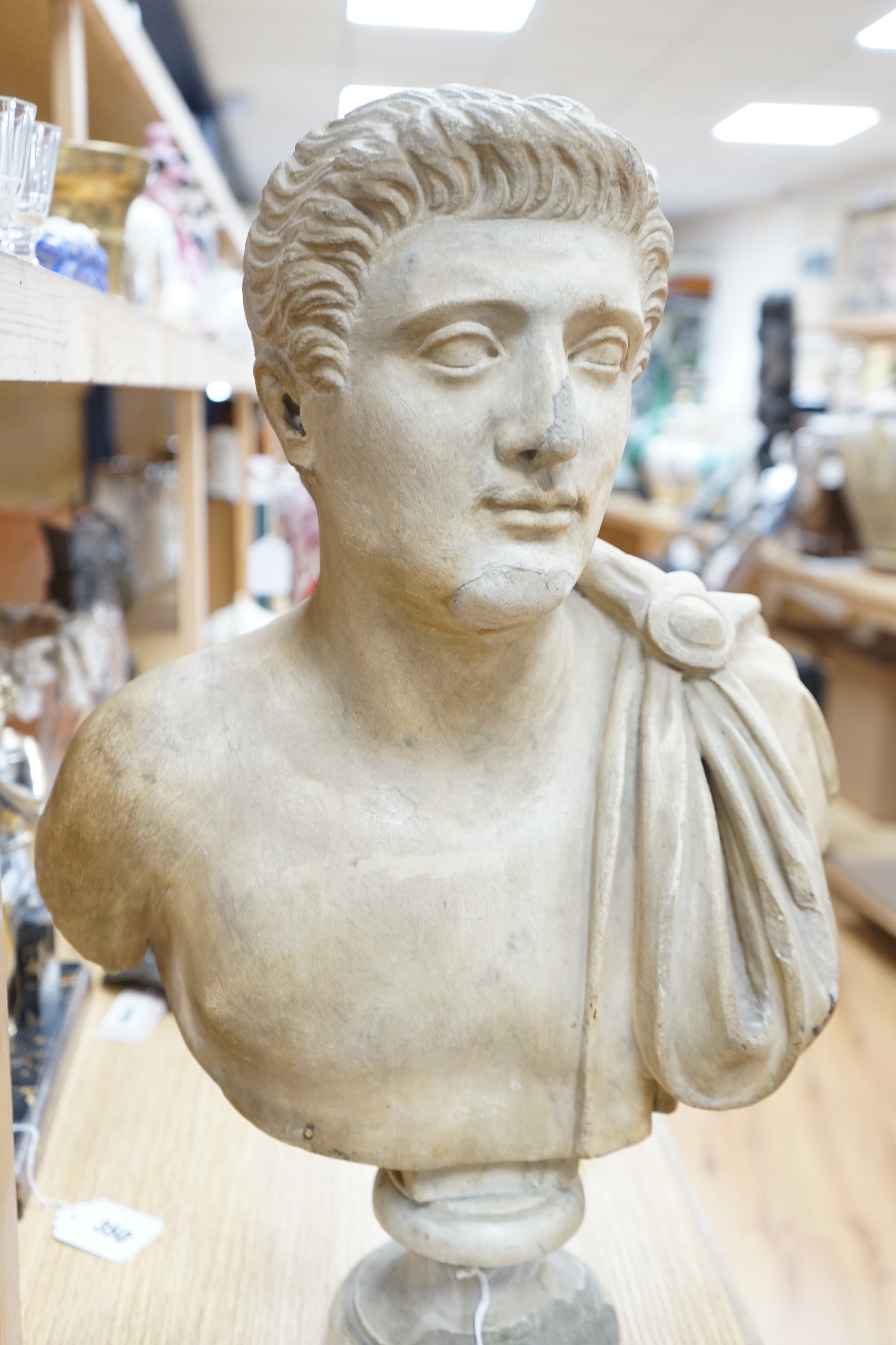 After the Antique marble bust of a Roman man wearing a Chlamys with a buckle at the shoulder, later socle and repairs, 54cm tall